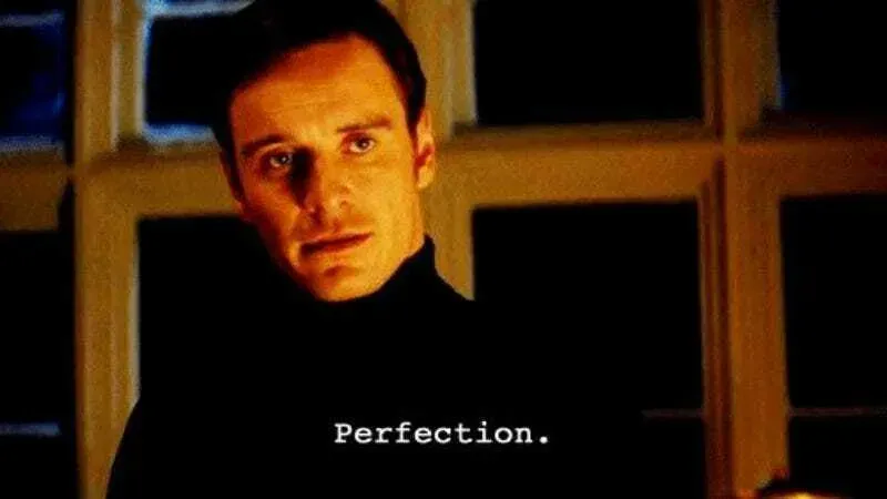 Movie still of a man in a black turtleneck saying “Perfection.”